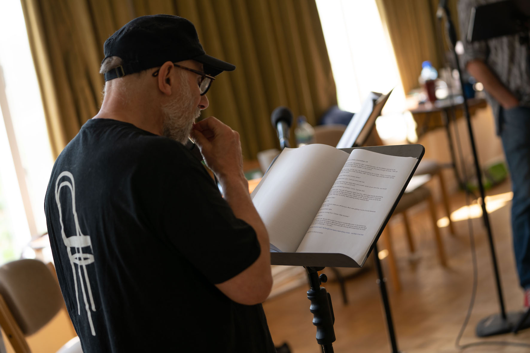 Simon McBurney looks questioningly down at the script, which is on a music stand