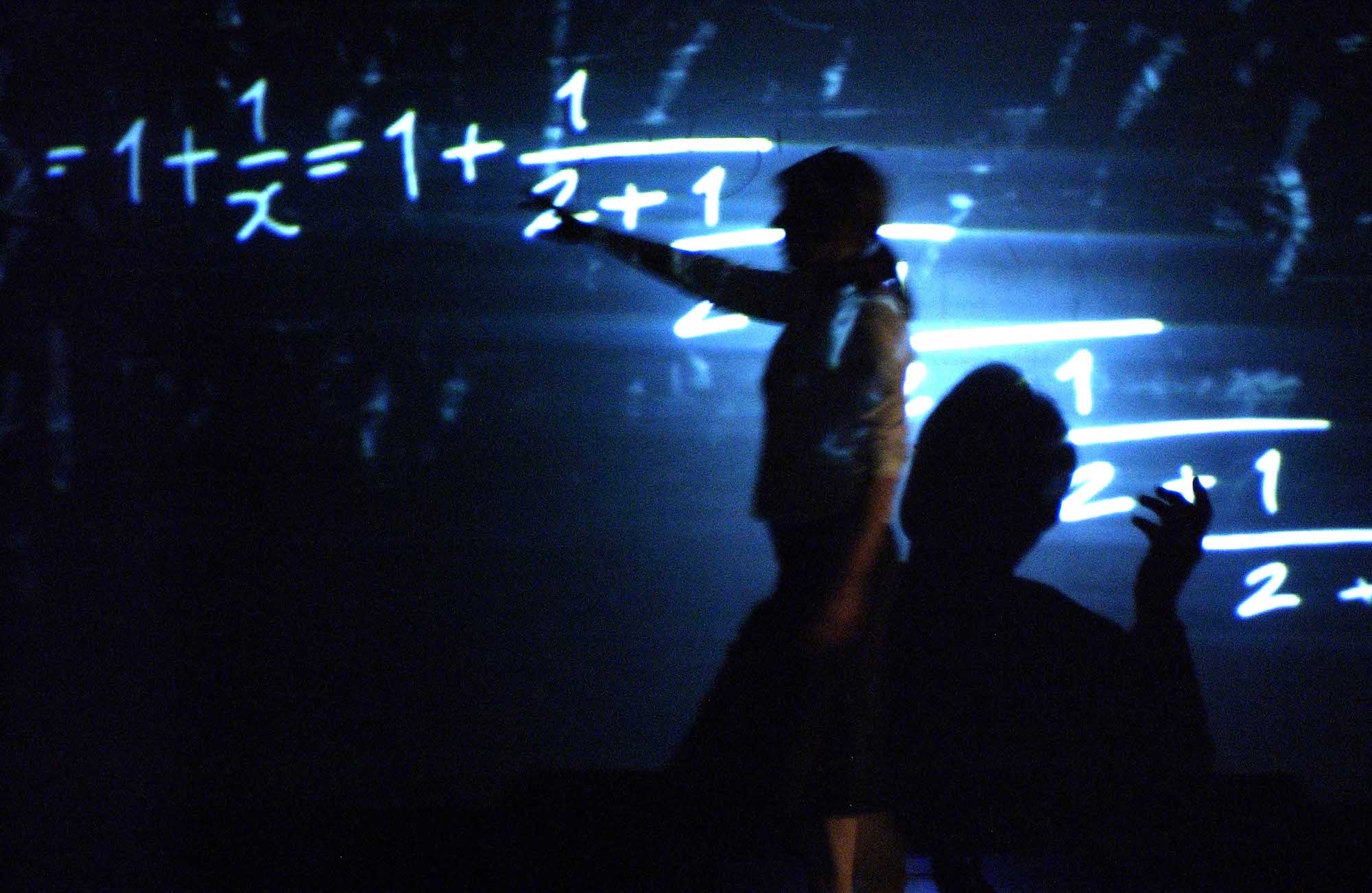 Two shadowy figures discuss the mathematical theorems projected onto the walls behind them in a blue light